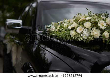 A black wedding car decorated with white roses, bridal bouquet, just married Foto stock © 