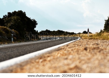 Scenic view on the gravel road with stones and vegetation on roadsides, selective focus. High quality photo