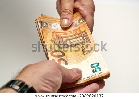 Photo of Close-up of two hands of people exchange a 50 euro notes to buy and sell. High quality photo