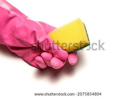 A hand in a rubber glove holds a dishwashing sponge. Cleaning concept. High quality photo