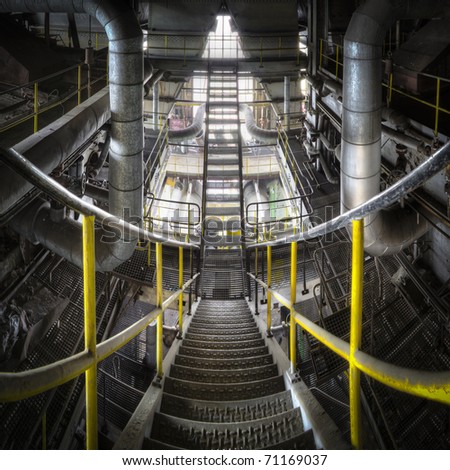Sliding down the stairs with our eyes, floating between the lines to go down to the next floor. A great overlook of a metal constructed staircase inside the belly of this huge power plant.