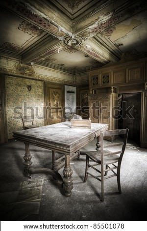 A creepy scenery, this old table and chair waiting for a person to take a seat.