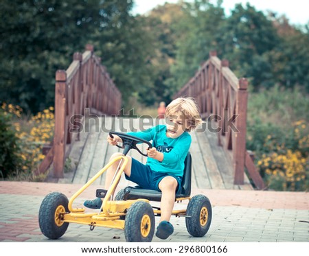 Young boy driving pedal go-kart very fast