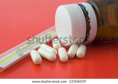 Bottle of pills and old thermometer
