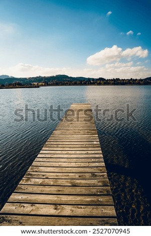 Foto Bild Bootssteg oder Badesteg aus schönem alten Holz im Sommer bei Sonnenschein am Alpsee in Schwangau bei Füssen im Allgäu im Freistaat Bayern