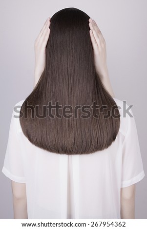 art fashion portrait of women hands on beautiful healthy long hair.back of brunette girl