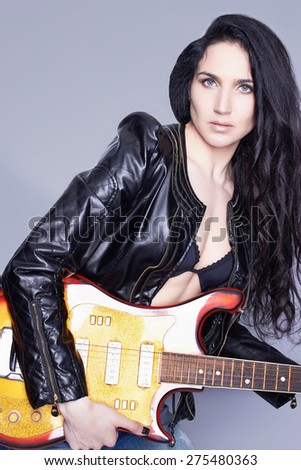 beautiful young woman with electric guitar.sexy girl in leather.rock music