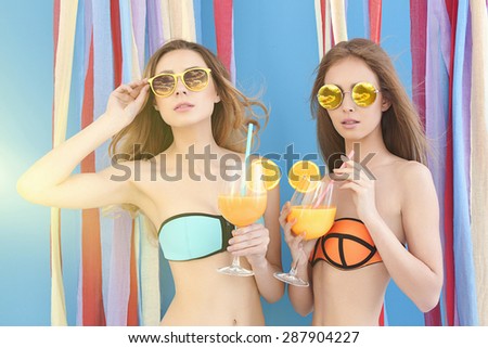 Two girls in bikini with cocktails. two beautiful sexy young women.summer beach party