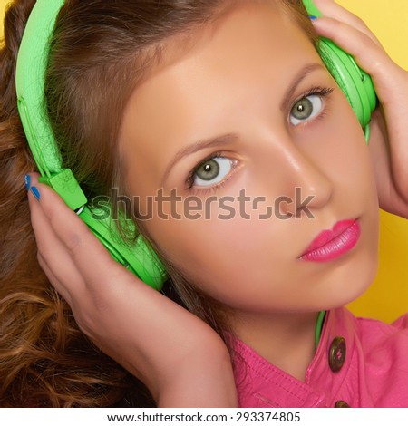 teen girl listening music on headphones.beautiful girl.Green headphones