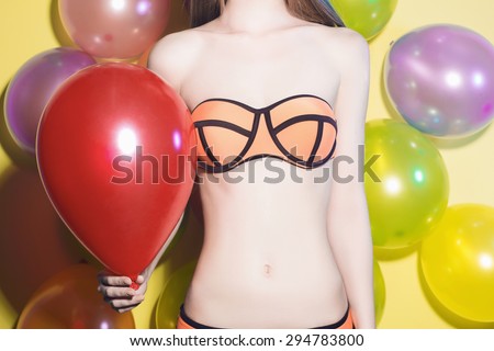 beauty body of young woman in bikini.girl on a party.color balloons