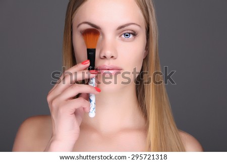 young blonde woman with make-up brush.girl Cosmetic. Base for Perfect Make-up.Applying Make-up