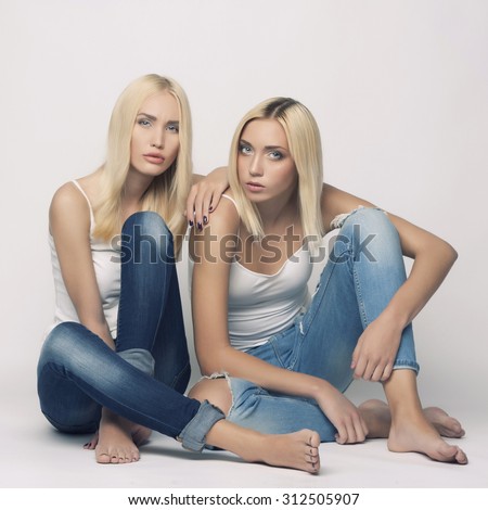 Two young beautiful woman twins blonde. sexy twins couple. girls