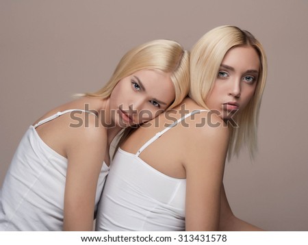 Two young beautiful woman twins blonde. sexy twins couple.girls