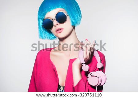 techno girl with blue hair.music on headphones. Fashion portrait of beautiful young Woman with bob hair.dj.sunglasses