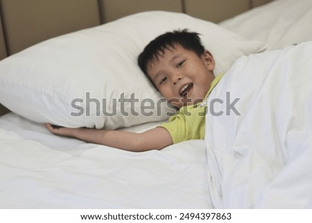 Image, Stock Photo Boy lying on a sofa using the laptop