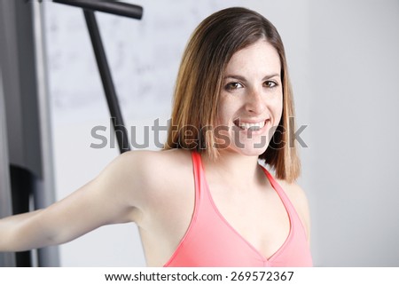 Strong woman weightlifting at the gym looking happy.