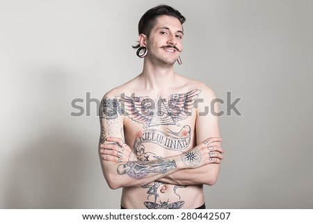 beautiful tattooed man on wall.