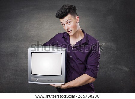 Happy man looking out of a television, holding it in his hands.