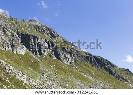 beautiful green mountain in switzerland with grass and blue sky on summer end period