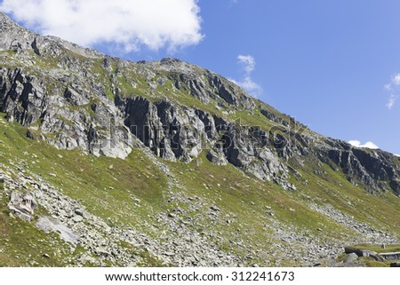 beautiful green mountain in switzerland with grass and blue sky on summer end period