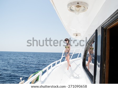 Photo of the Beautiful young woman in sun glasses on yacht, open sea