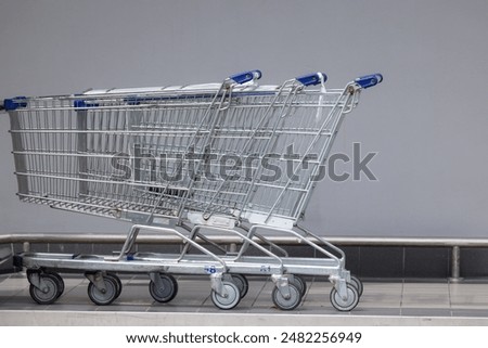 Similar – Image, Stock Photo Lined up shopping trolleys made of shiny wire with red plastic in front of a new supermarket in Bielefeld in the Teutoburg Forest in East Westphalia-Lippe