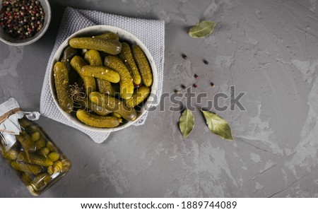 Plate of gherkins, pickled cucumbers on a grey concrete background. Clean eating, vegetarian food concept. Top view with space for text Photo stock © 