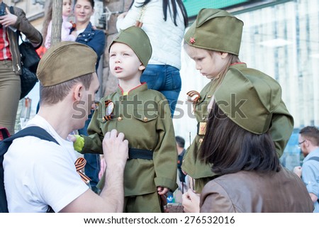 MOSCOW, RUSSIA - MAY 09, 2014: Parents with their children during march of \'Immortal Regiment\'. Kids are wearing military uniform