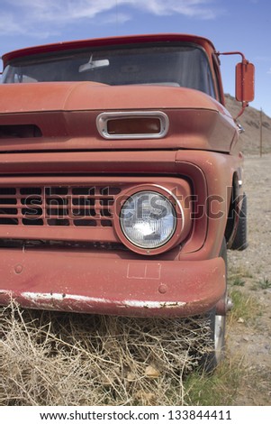 an old rusty pickup truck in the desert. Blue skies and tumbleweeds.