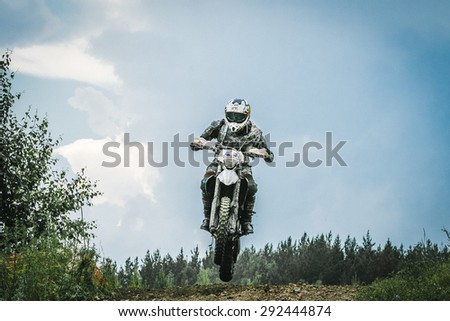 Kyshtym, Russia - June 21, 2015: Motocross driver jump over the mountain during the race Urals Cup of Enduro \