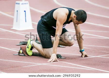 Chelyabinsk, Russia - July 05, 2015: Man athlete in starting position during Championship of Russia on track and field athletics among the blind, Chelyabinsk, Russia - July 05, 2015