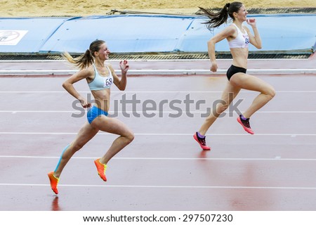 Chelyabinsk, Russia - July 10, 2015: girl athletes run 400 meters in the rain during Championship of Chelyabinsk on track and field athletics, Chelyabinsk, Russia - July 10, 2015