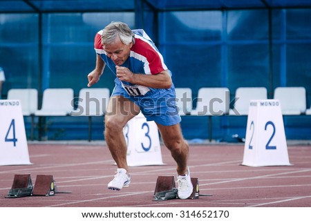 Chelyabinsk, Russia - August 28, 2015:  start old men from starting blocks during championship of Russia on track and field athletics among the elderly, Chelyabinsk, Russia - August 28, 2015