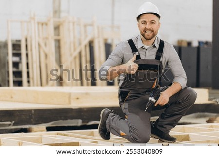 Similar – Geschulter Zimmermann bei der Verarbeitung von Holzbrettern