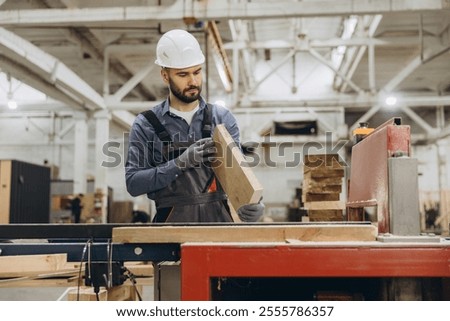 Similar – Geschulter Zimmermann bei der Verarbeitung von Holzbrettern