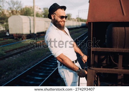 bearded man in a sunglasses posing on the old train