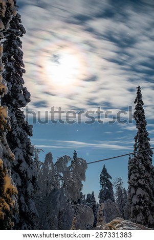 Long exposure shot of clouds moving in front of full moon at cold arctic winter night in Jullas, Finland.