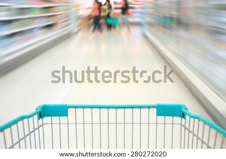 shopping cart in supermarket aisle motion blur