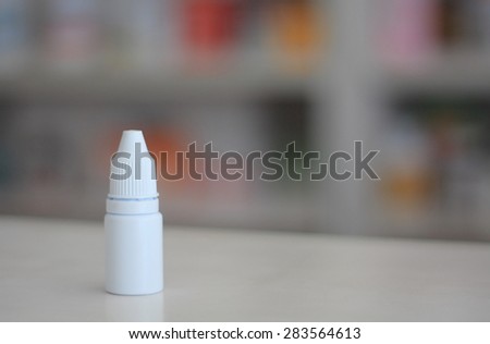 eye ear drops medicine bottle with pharmacy store shelves background