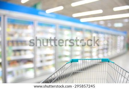 Shopping Cart View in Supermarket Aisle Milk Yogurt Frozen Food Freezer and Shelves with customer defocus background