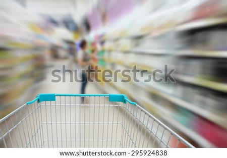 blurred health product shelves in supermarket for background with shopping cart
