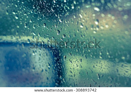 abstract natural rain water drops on glass of car window with vintage filter