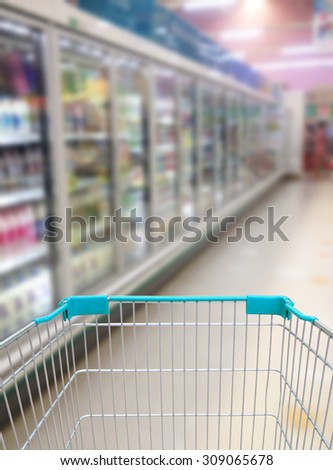 Shopping cart view in Supermarket Aisle Milk Yogurt Frozen Food Freezer and Shelves blurred background