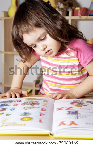 Little Girl Learning Figures and Letters with Picture Book