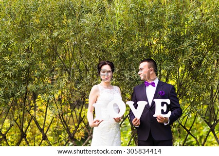 bride and groom with wooden word. Word Love