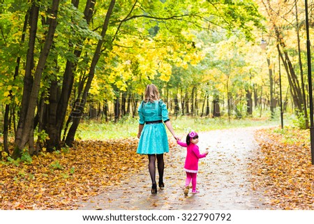 mother with her daughter for a walk in autumn park