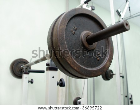 fitness heavy barbell in white holder in gym club