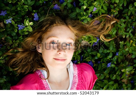 tween girl laying in a field of periwinkle