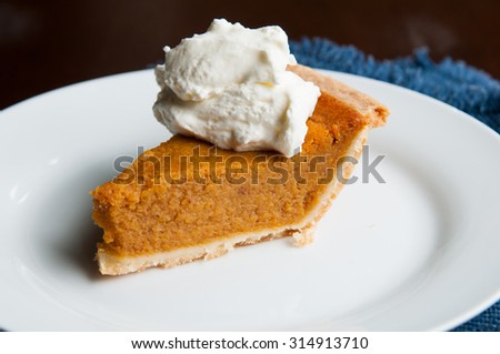 piece of pumpkin pie on a plate with a dollop of whipped cream