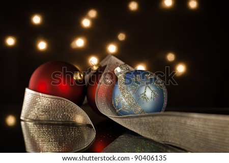 A close up of three christmas ornaments with a silver ribbon.
